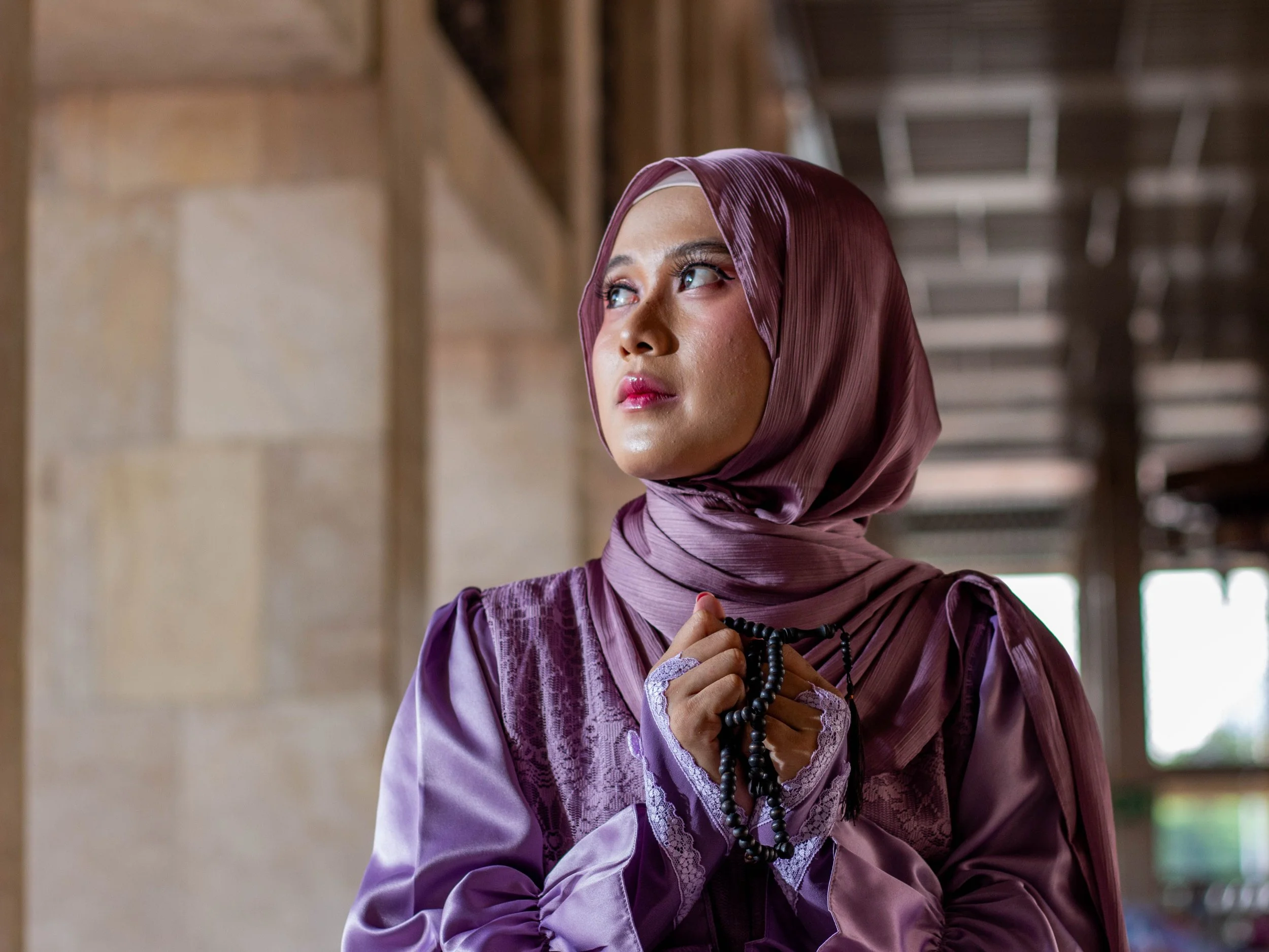 muslim student looking thoughful and sad, with tasbeeh in hand