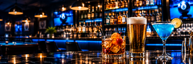 A cocktail and a draft beer on the bar