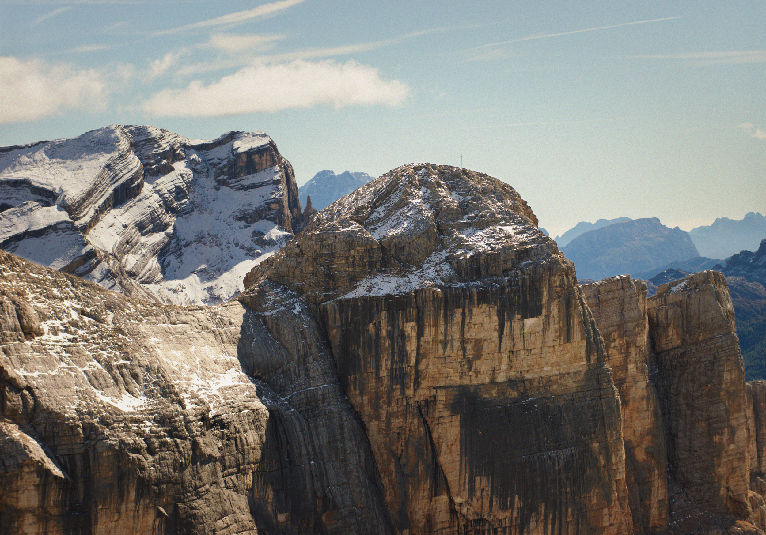 Snow-capped mountain peaks under a partly cloudy sky.