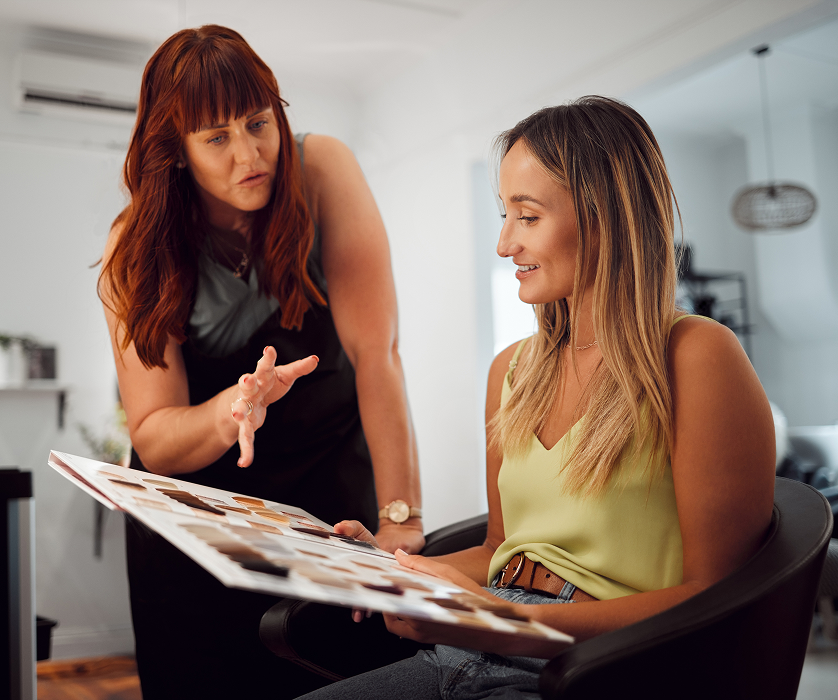 Hair stylist reviewing style ideas with a client at a women's hair salon in Chicago.