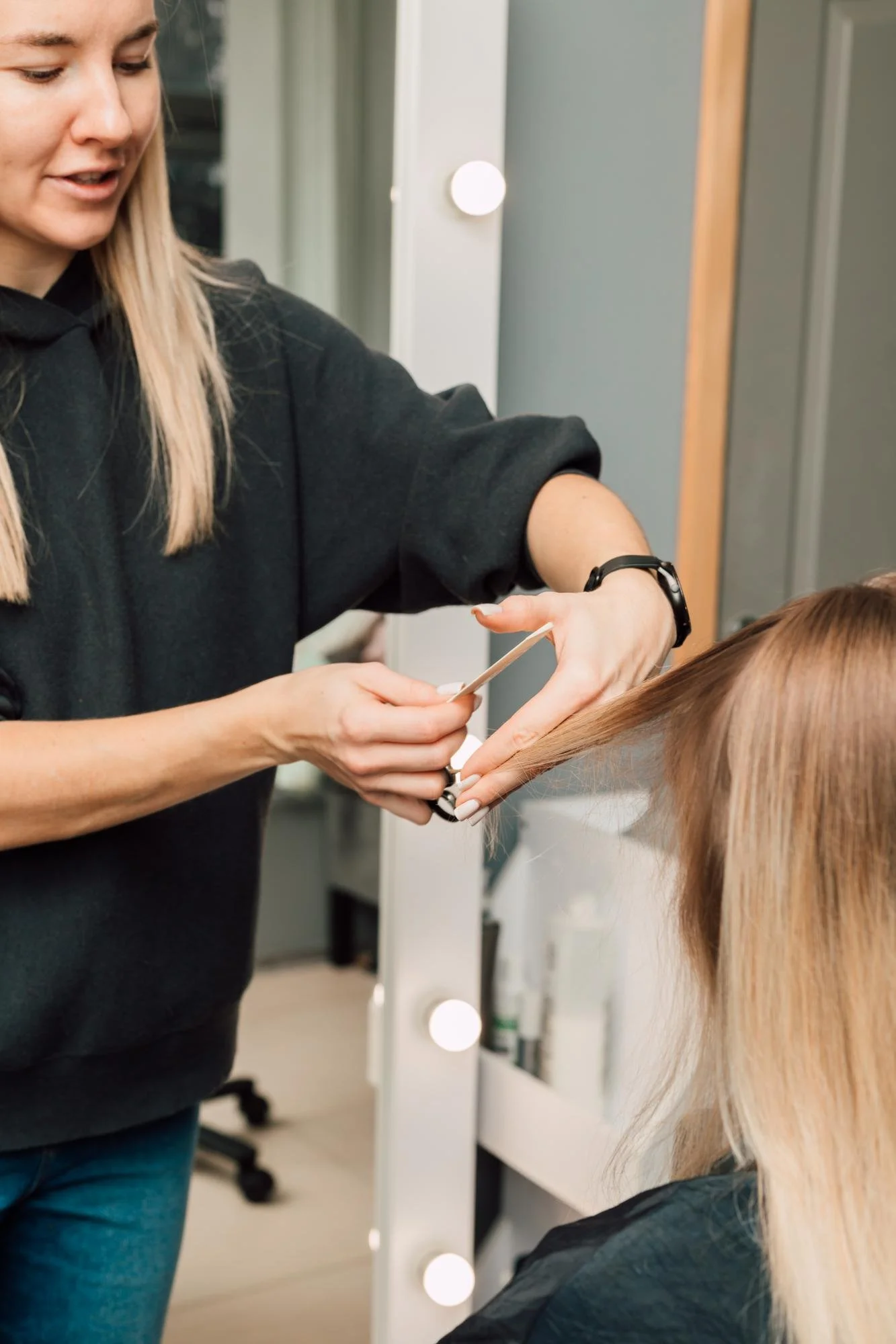 A woman’s hair being shaped with scissors in a salon, representing expert stylist guidance for women’s haircuts.