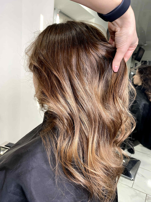 Brunette balayage waves catch soft light through loose curls