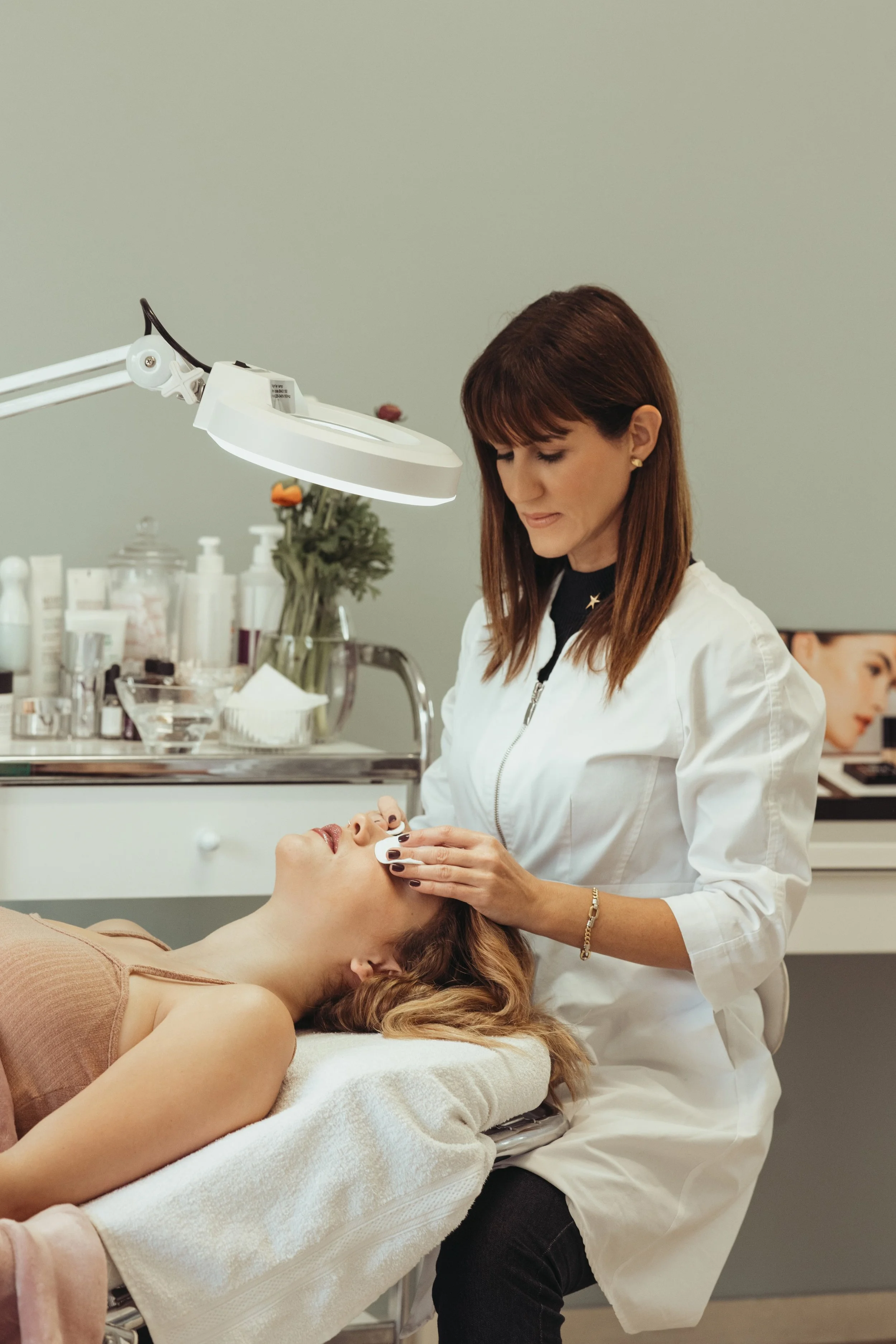 Skincare professional performing a dermaplaning facial treatment on a client.
