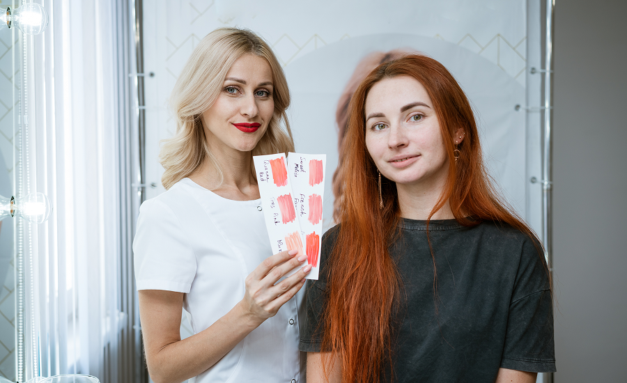 Hairstylist reviewing hair color methods with a client, demonstrating the difference between balayage and highlights through professional advice.