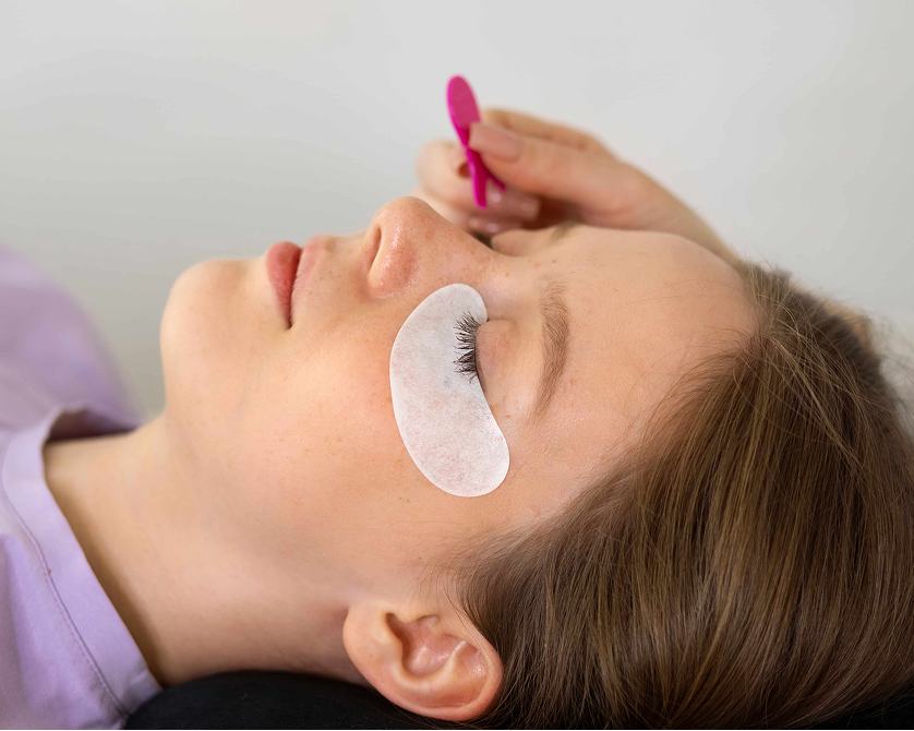 Lash specialist applying color for a natural lash tint treatment during a beauty session.
