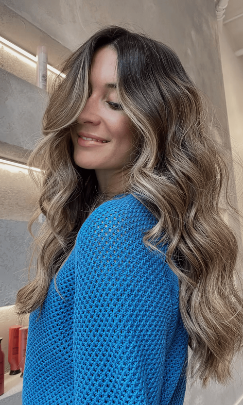 Face-framing highlights brighten wavy layers with soft dimension