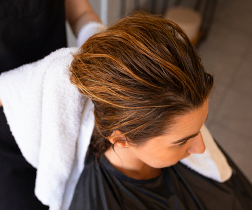 A colorist reviewing hair color swatches with a client during a balayage consultation at a hair salon.