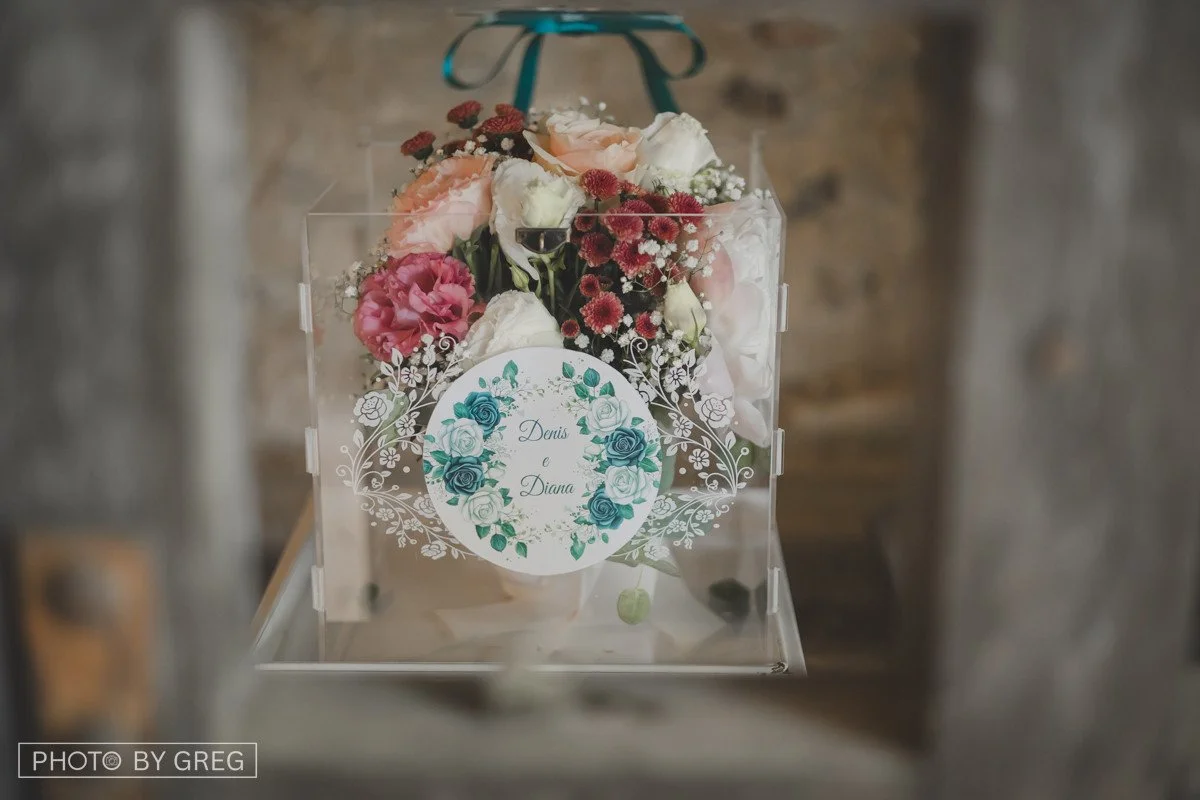 Bouquet custodito in un box trasparente decorato con nastri, per il gioco della chiave durante il matrimonio.