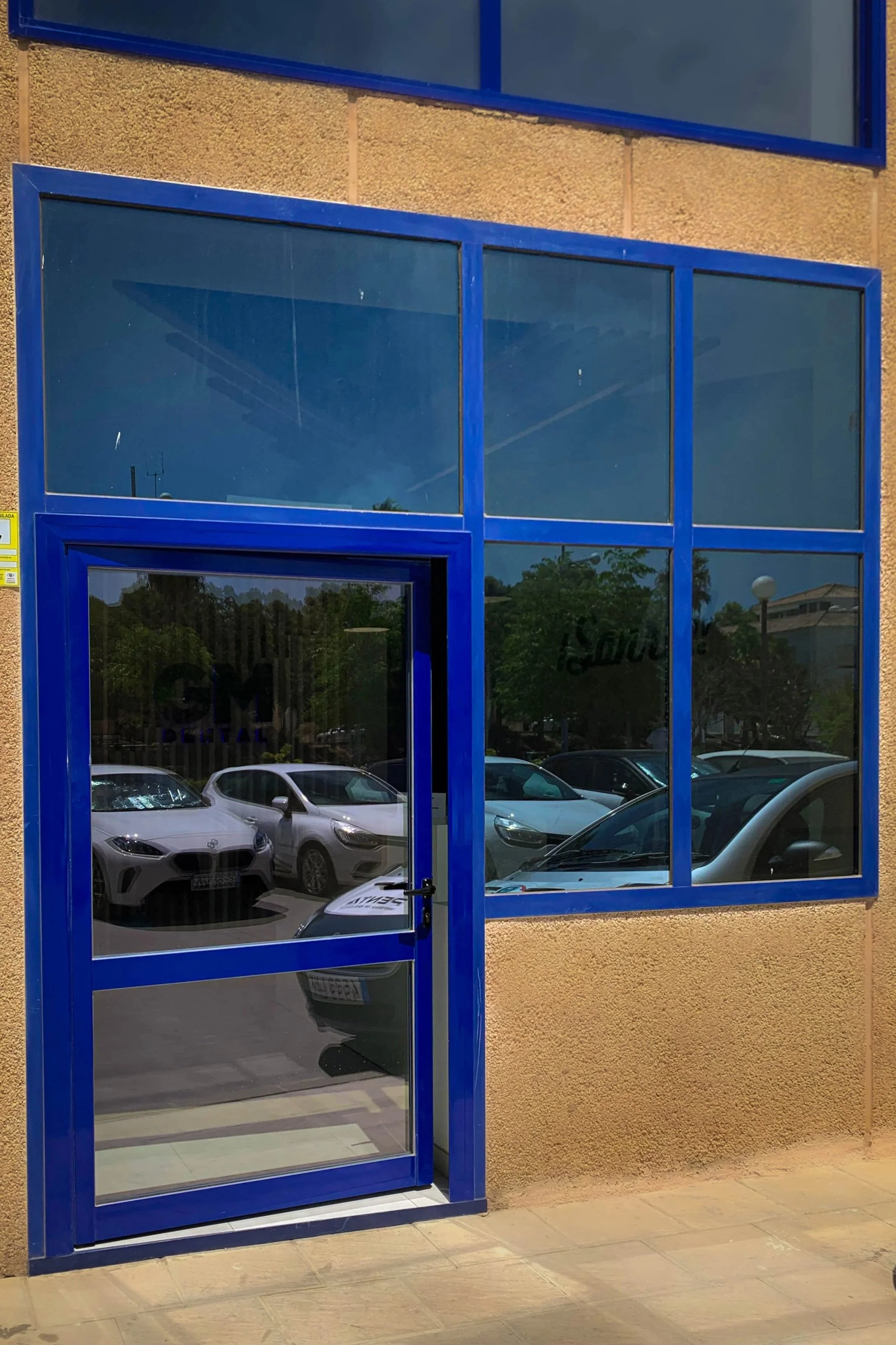 Puerta de aluminio azul con cristales fijos tipo Climalit para aislamiento térmico. Puerta de oficina, local o tienda.