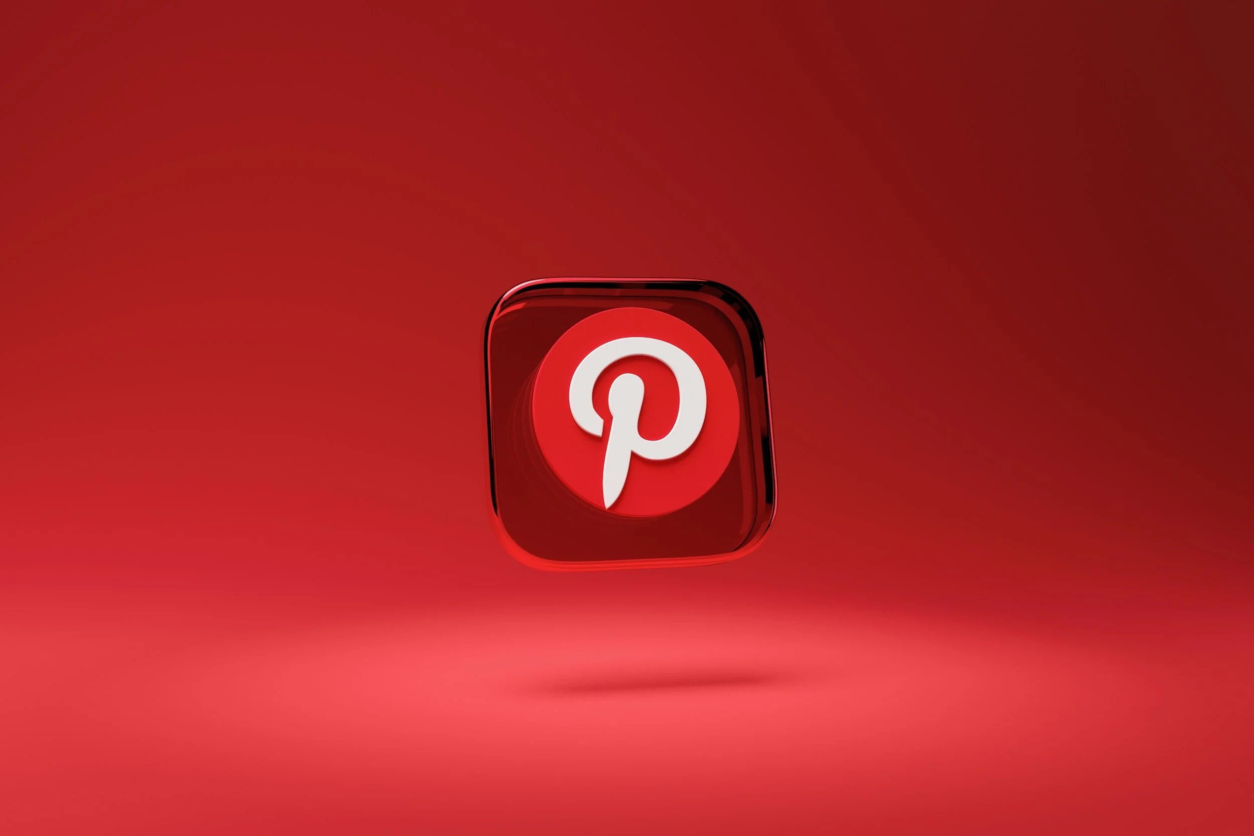 Red 3D Pinterest app icon floating on a red background.