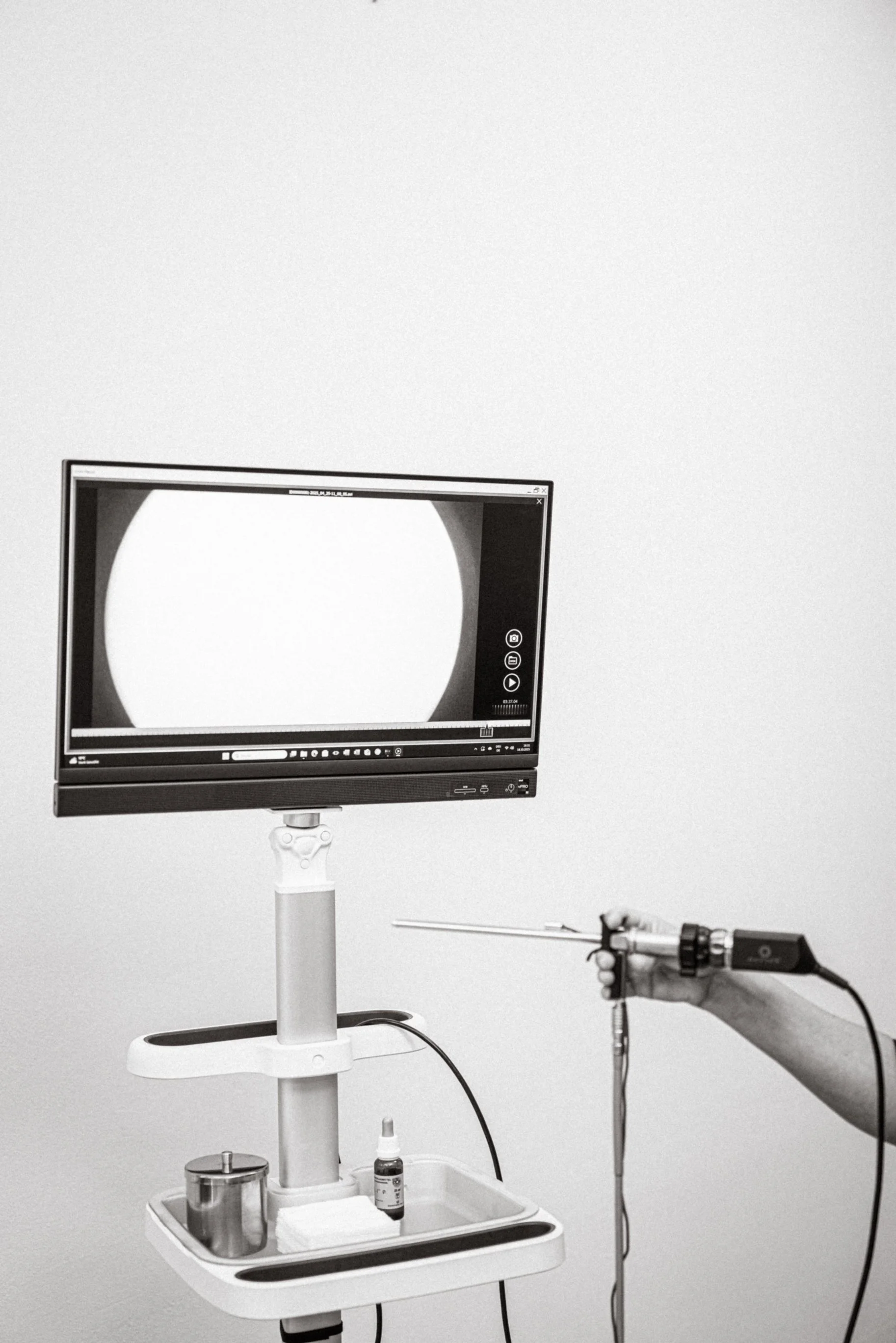 Ein medizinisches Gerät auf einem weißen Rollständer mit Monitor, einer Pipette und Medikamentenbehältern. Es befindet sich in der Arztpraxis von  Dr. Antonia Tardue-Breiter.