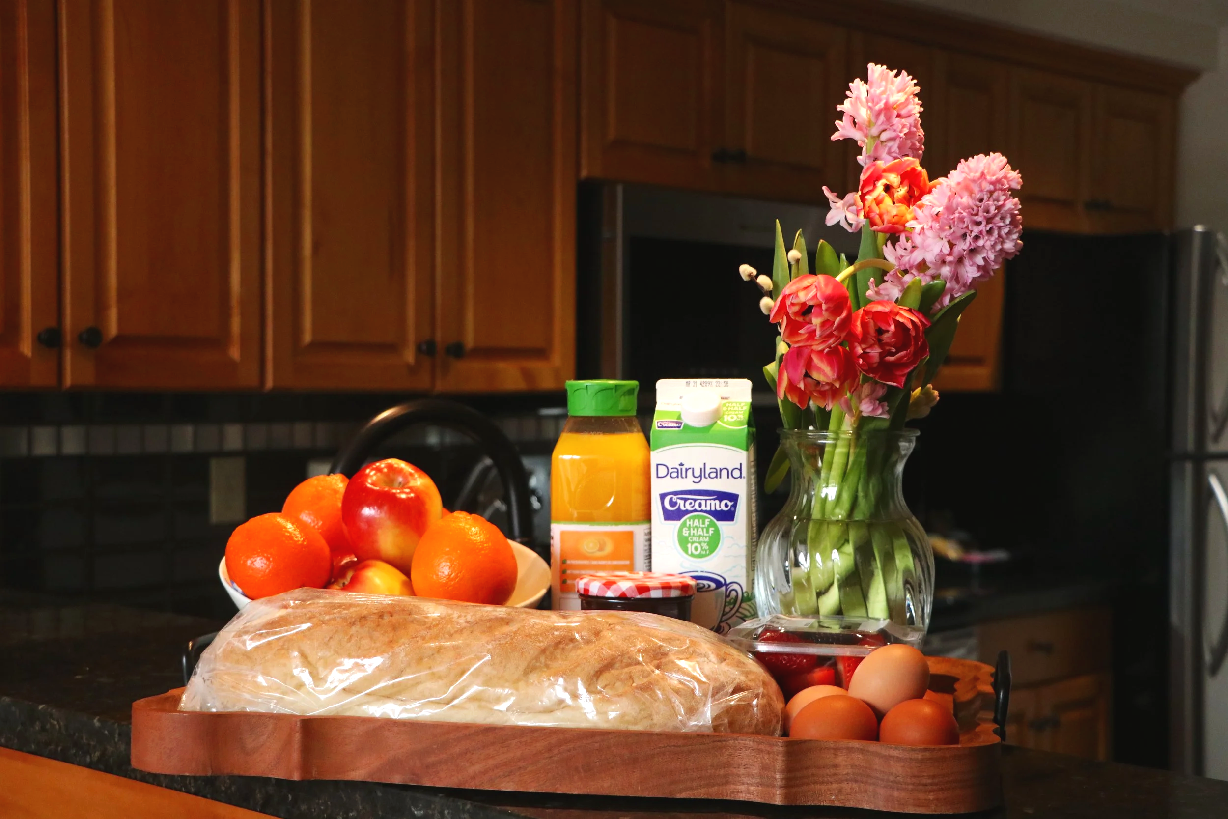 Breakfast essentials ready in the fridge for late-arriving guests, including milk, eggs, bread, and fruit for an easy morning meal