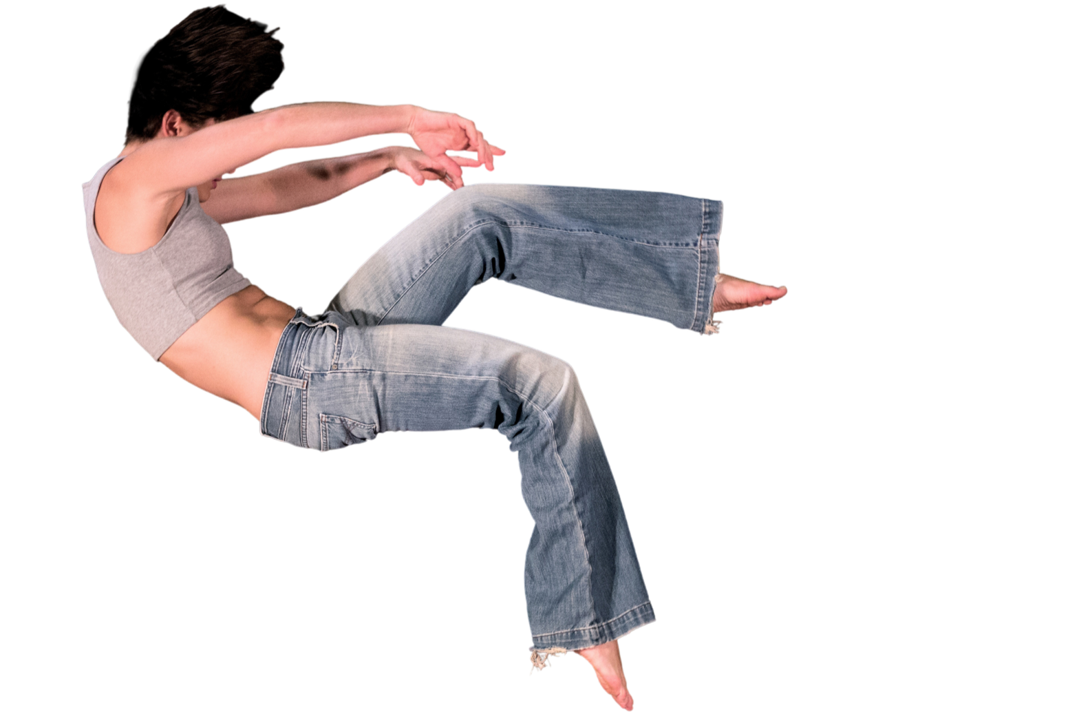 A woman with dark hair, wearing a gray sleeveless crop top and loose blue jeans, is in a reclined back position with her arms extended forward and her legs bent, as if falling or floating.