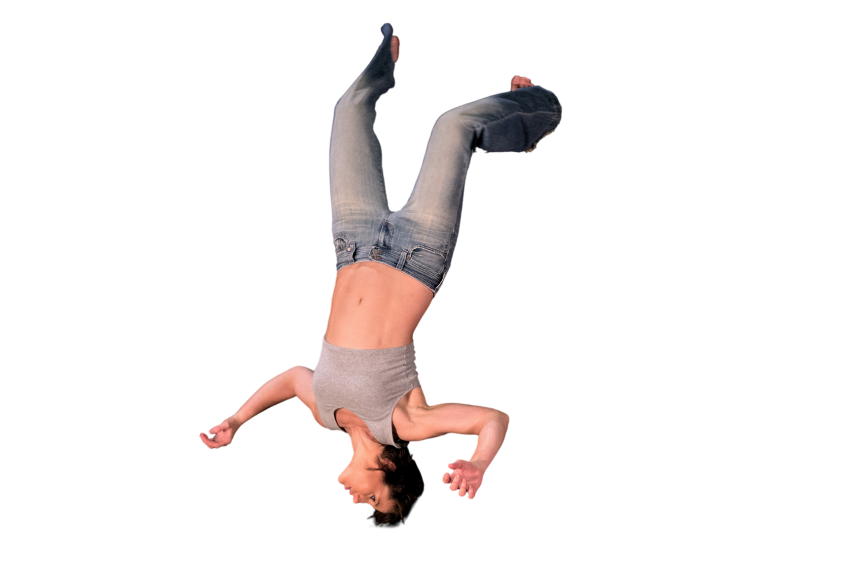 An upside-down woman with her arms extended and her legs bent, as if falling or floating against a transparent background, wearing a gray sleeveless top and blue jeans.