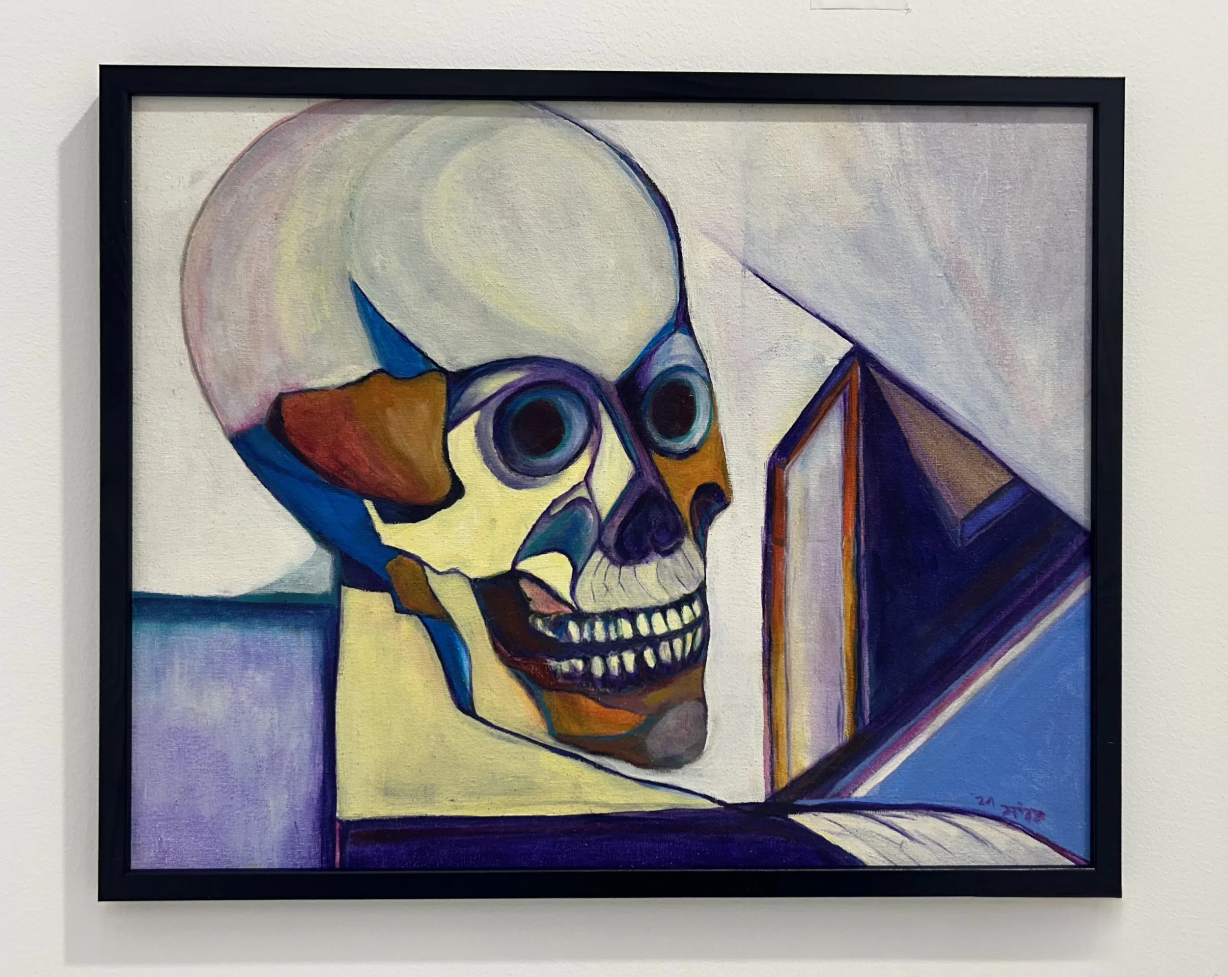 Colorful abstract painting of a human skull, framed and displayed on a white wall.