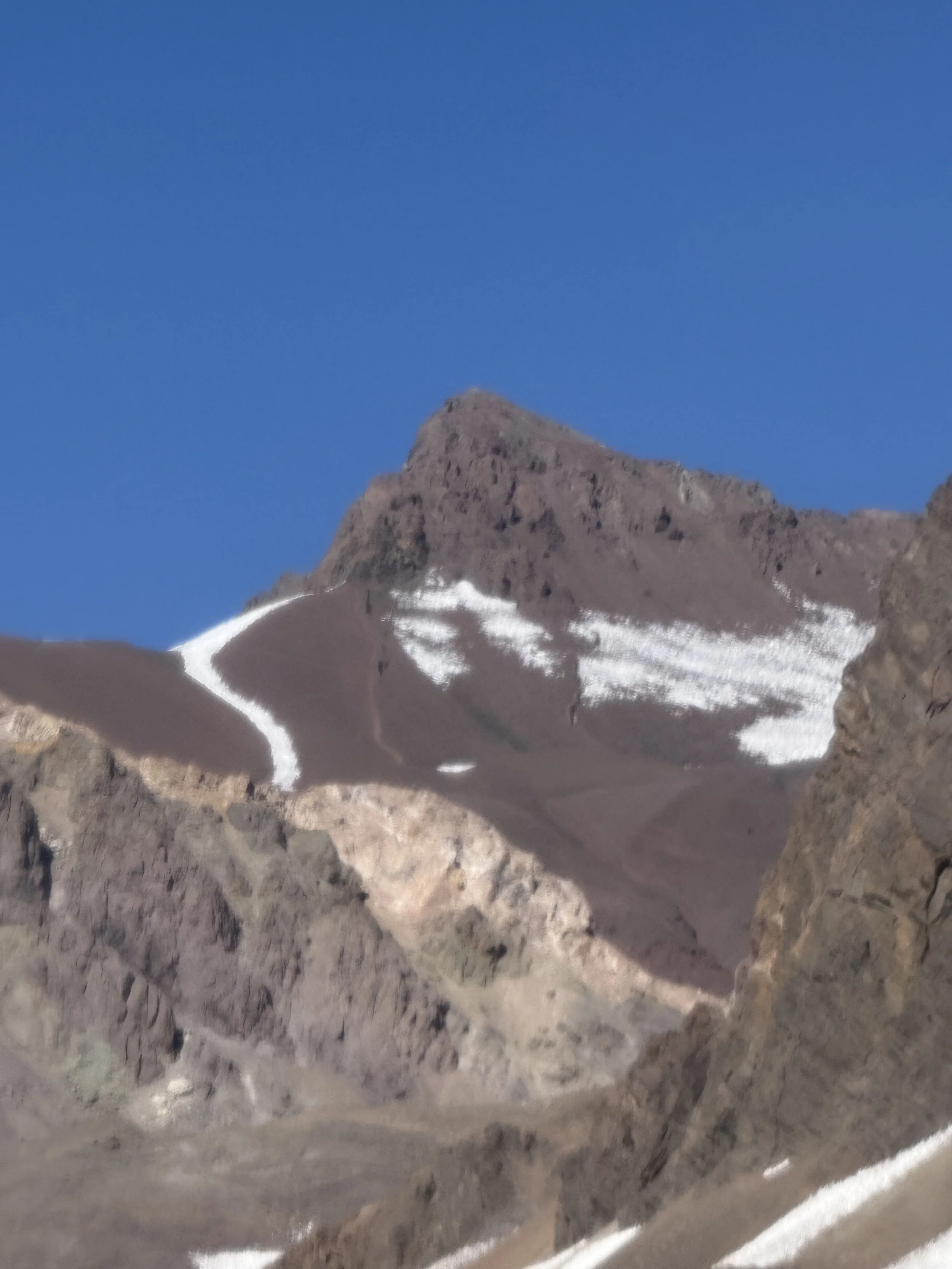 Mountains with patches of snow under a clear blue sky