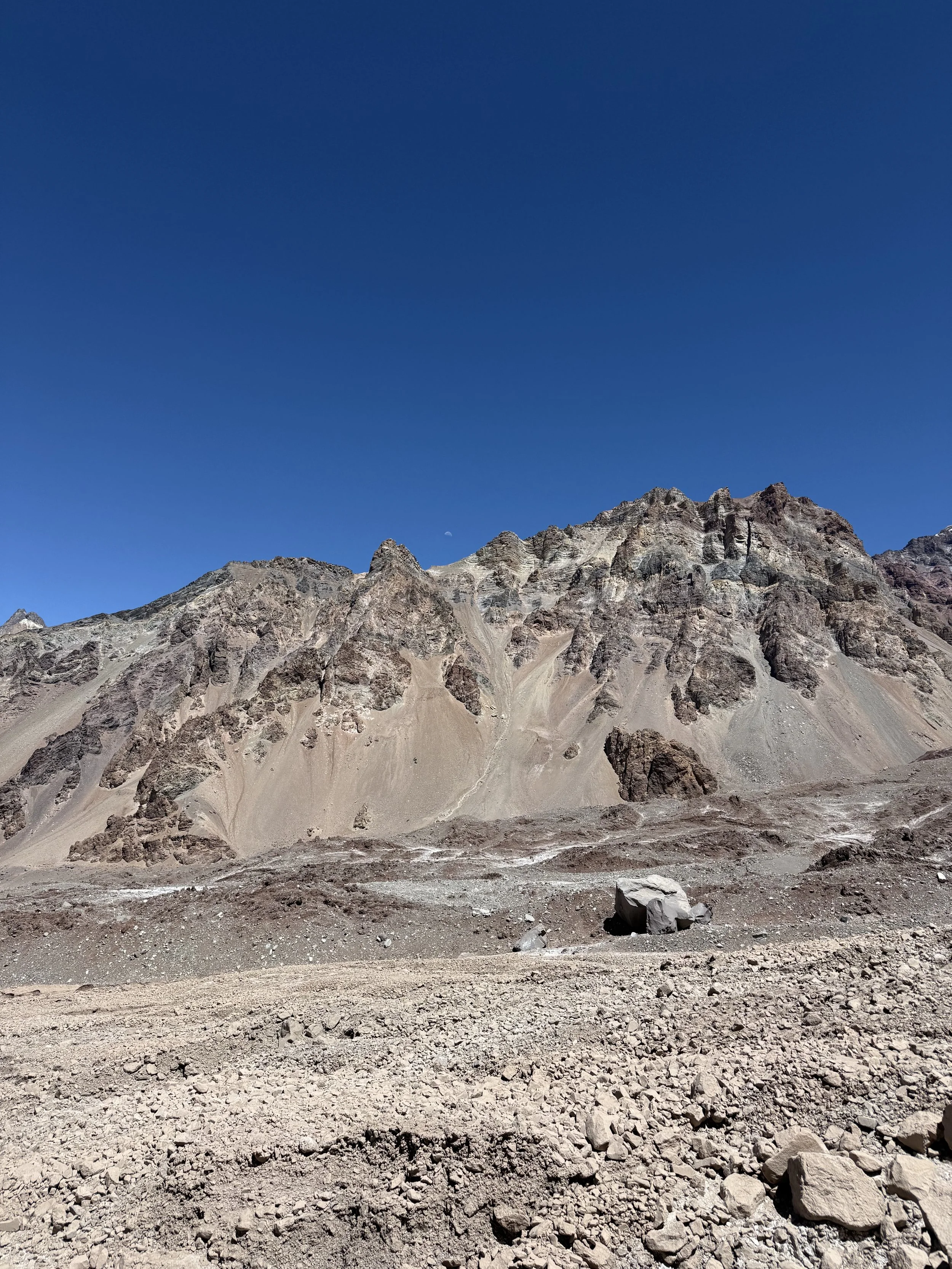 Desert landscape with rocky mountain range under a clear blue sky.