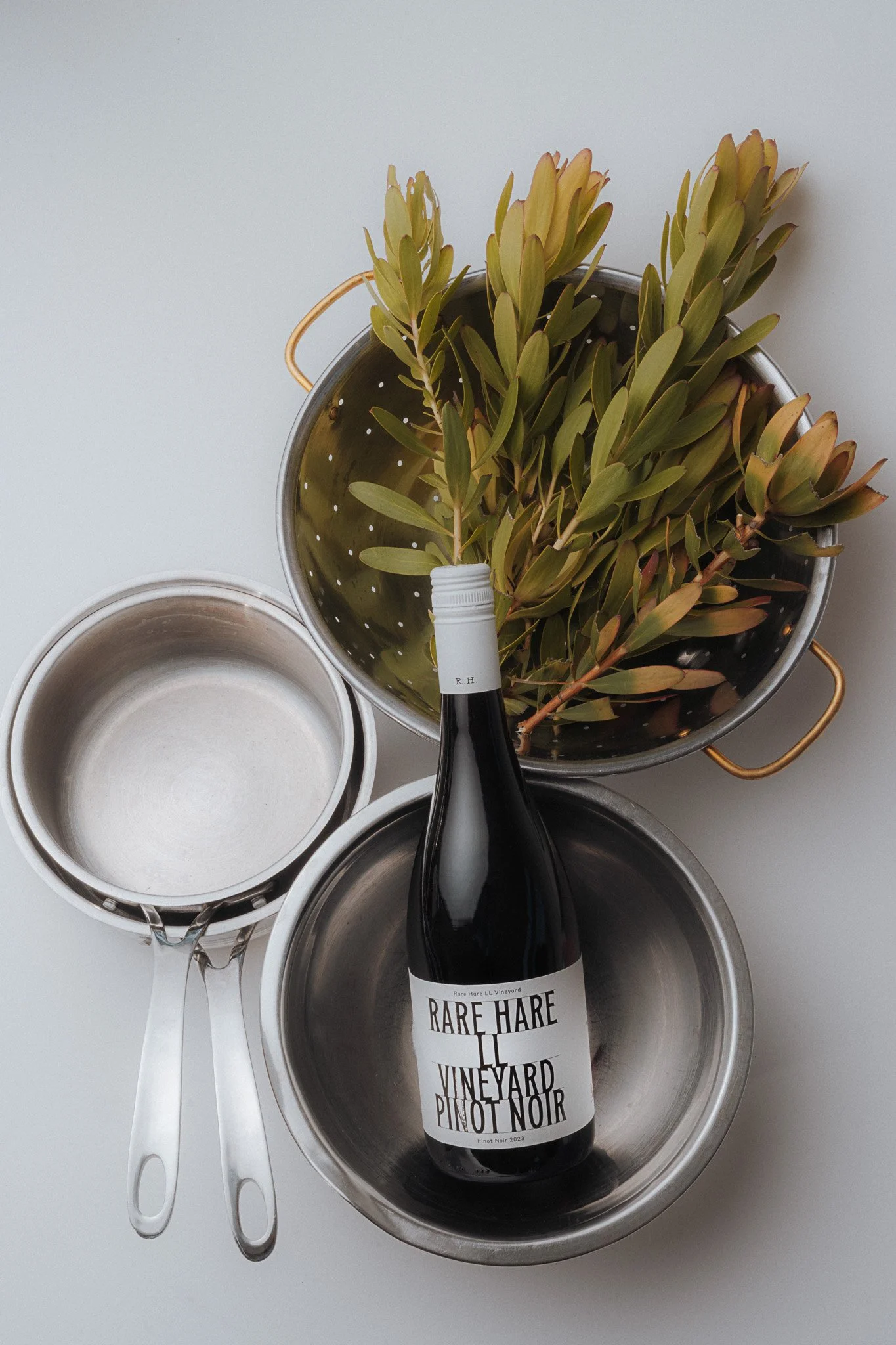 Rare Hare Vineyard Pinot Noir bottle styled with props – creative editorial photography kitchen props