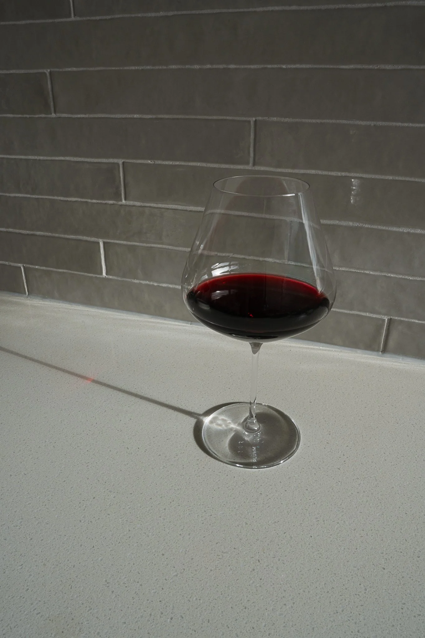 Plumm wine glass product photography – styled in kitchen with red wine