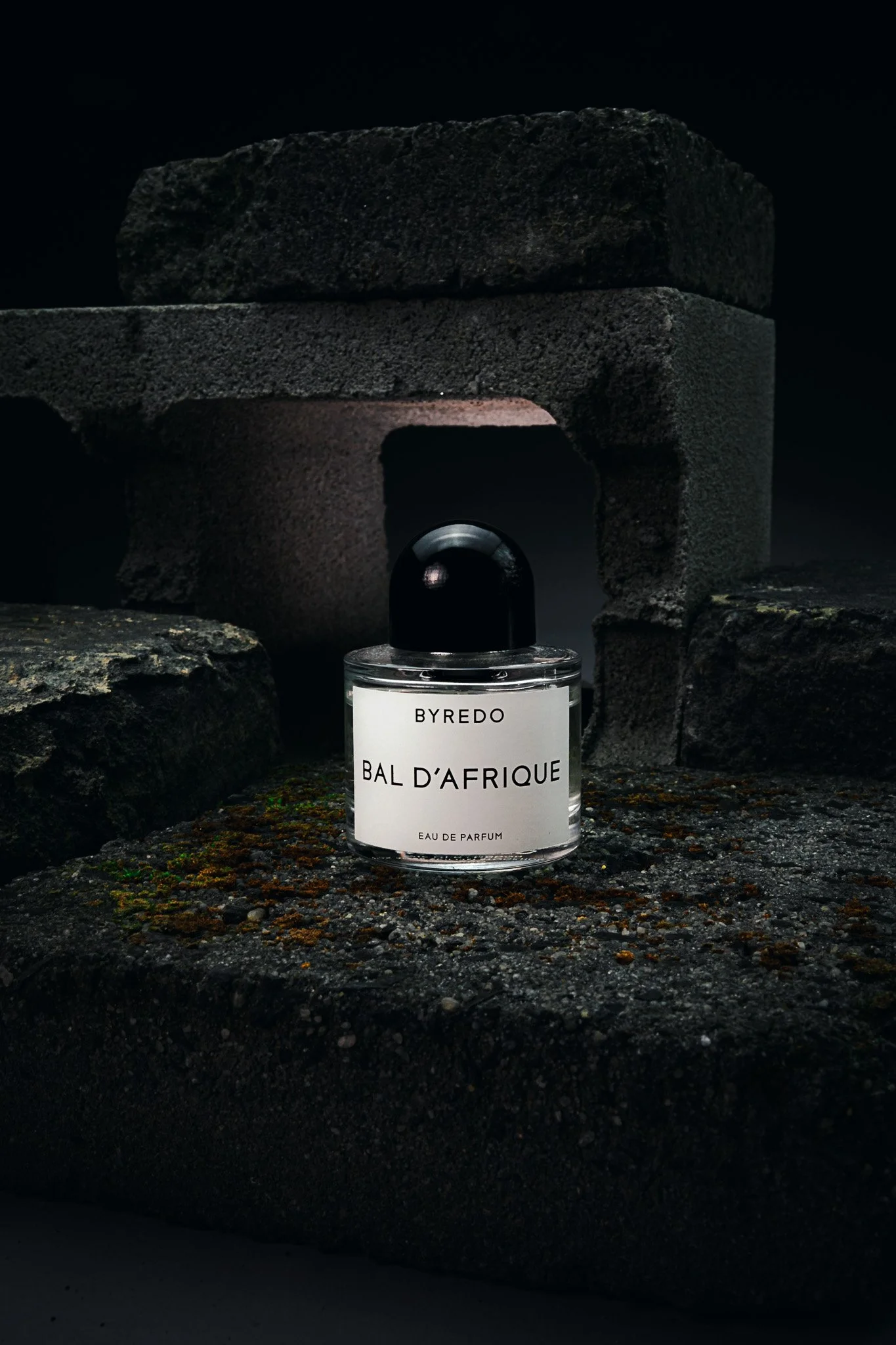 Byredo perfume photographed on mossy rocks – surreal editorial product photography