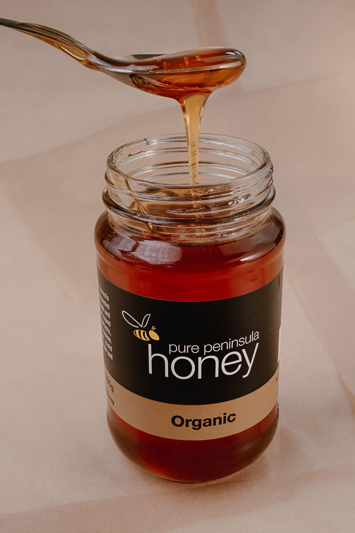 Pure Peninsula organic honey jar dripping honey – studio product photography