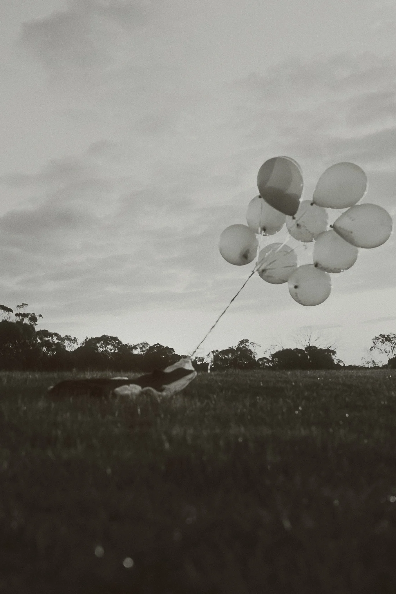 Arnsdorf fashion piece floating with red balloons – black and white editorial photography