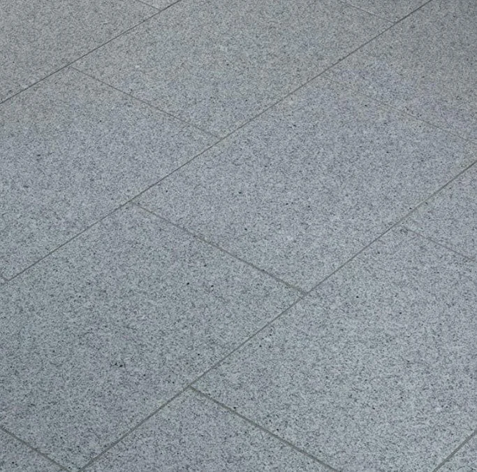 Sol en pierre gris avec dalles posées en diagonale.