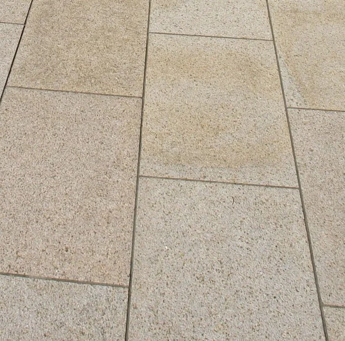 Sol en pierre beige avec des carreaux rectangulaires.