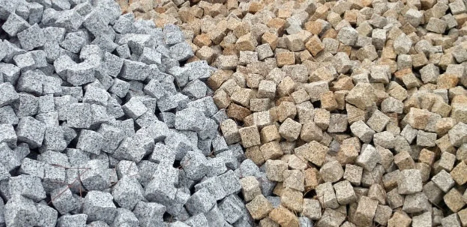 Deux amas de pavés en pierre, un gris et un beige, disposés côte à côte.