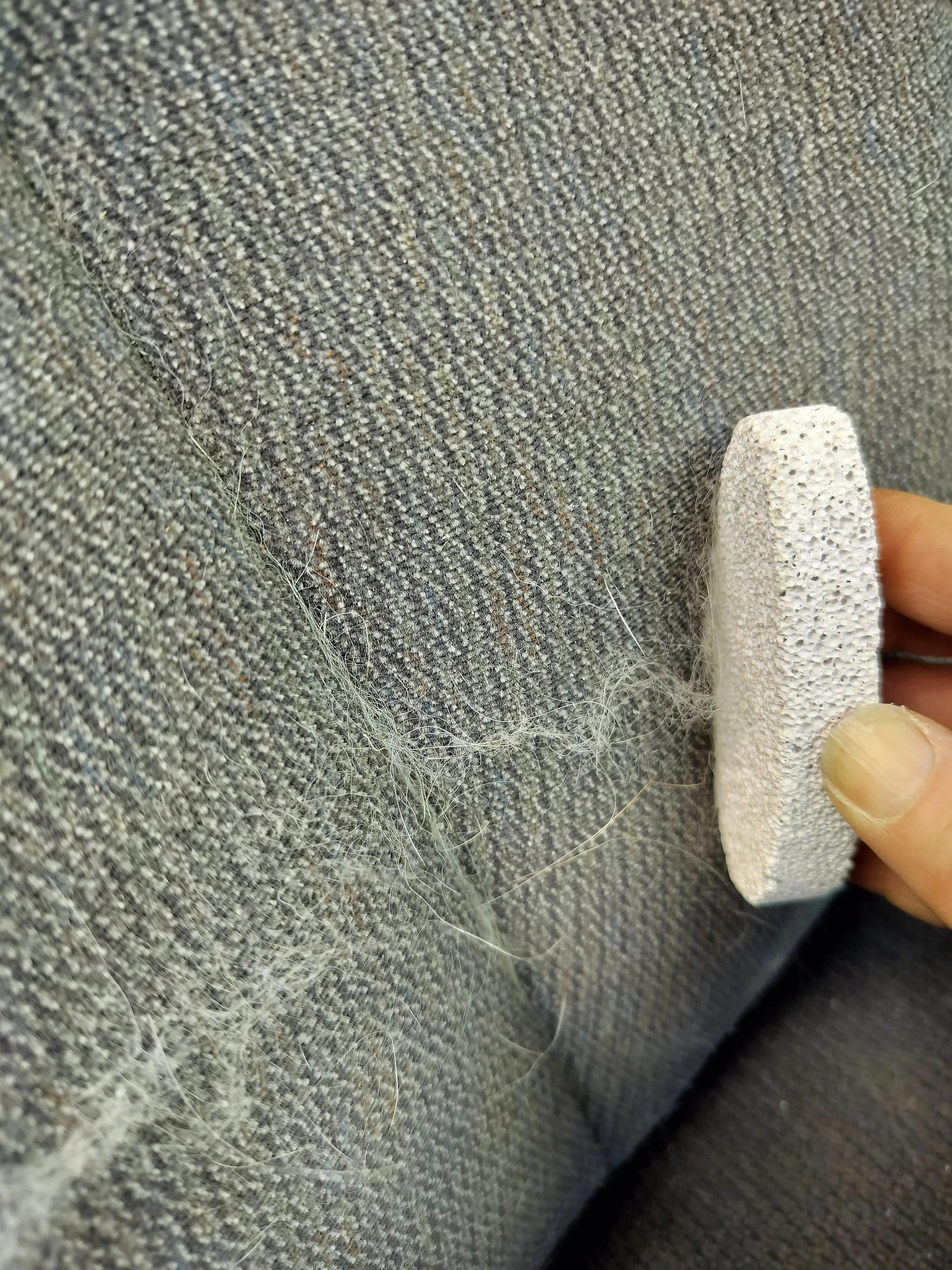 A pumice stone being used to remove pet hair from car upholstery