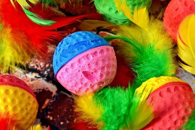 A collection of cat toys with brightly coloured balls and feathers
