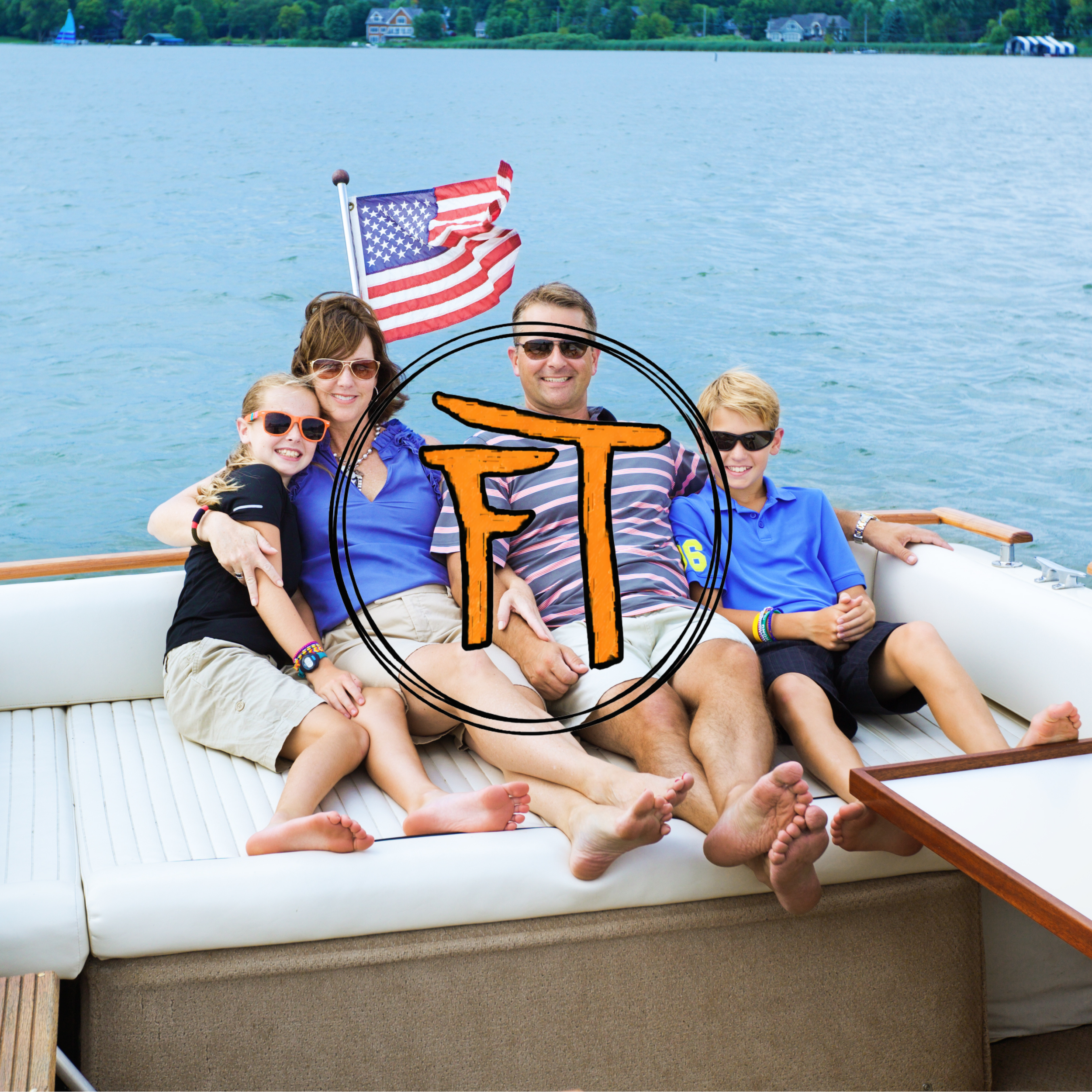 Family of four enjoying a boat ride on a lake, with an American flag waving behind them and trees in the background.
