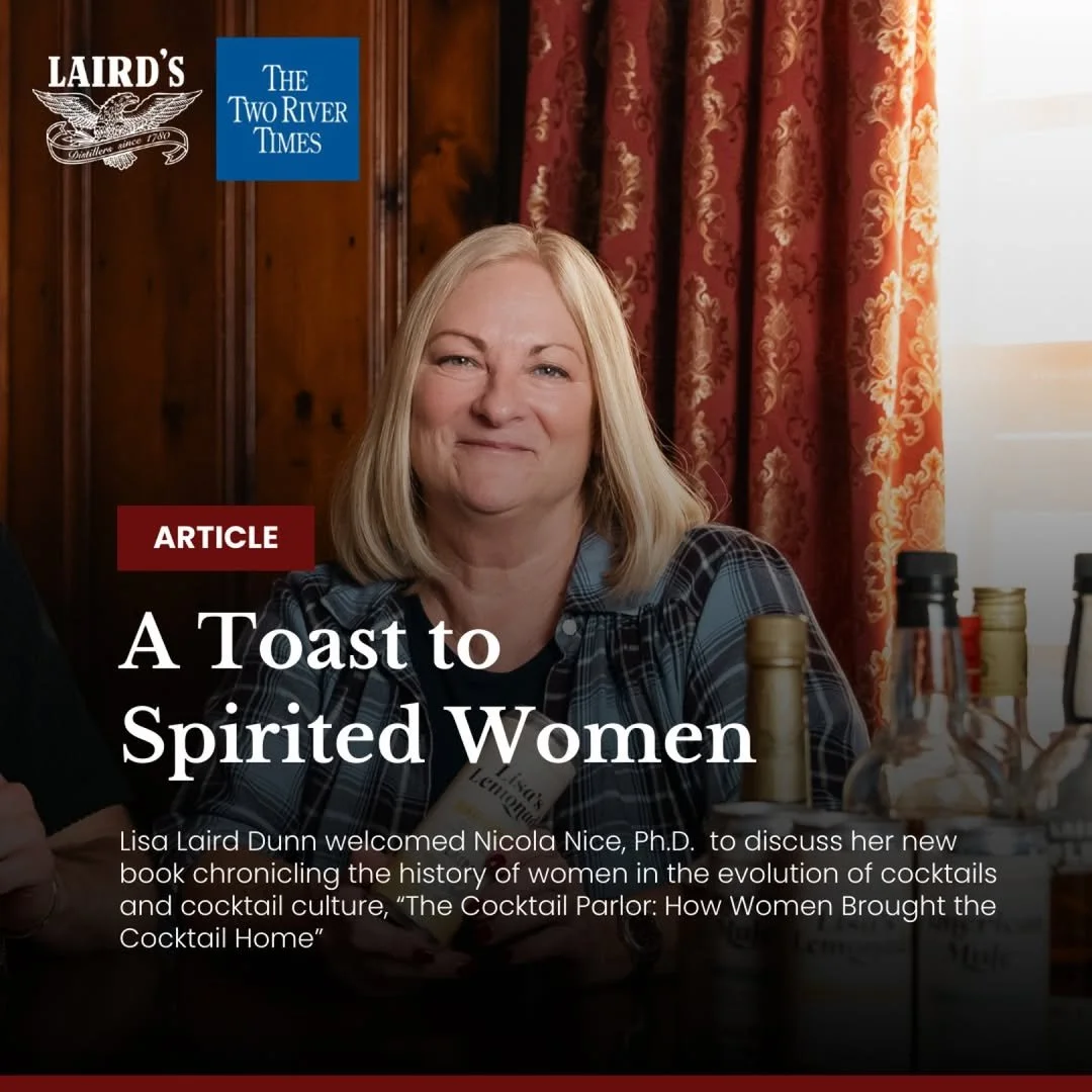 Woman with blonde hair smiling, sitting at a table with bottles in front, in front of red curtains and wooden paneling, promotional image for an article titled 'A Toast to Spirited Women' about women in cocktail culture.