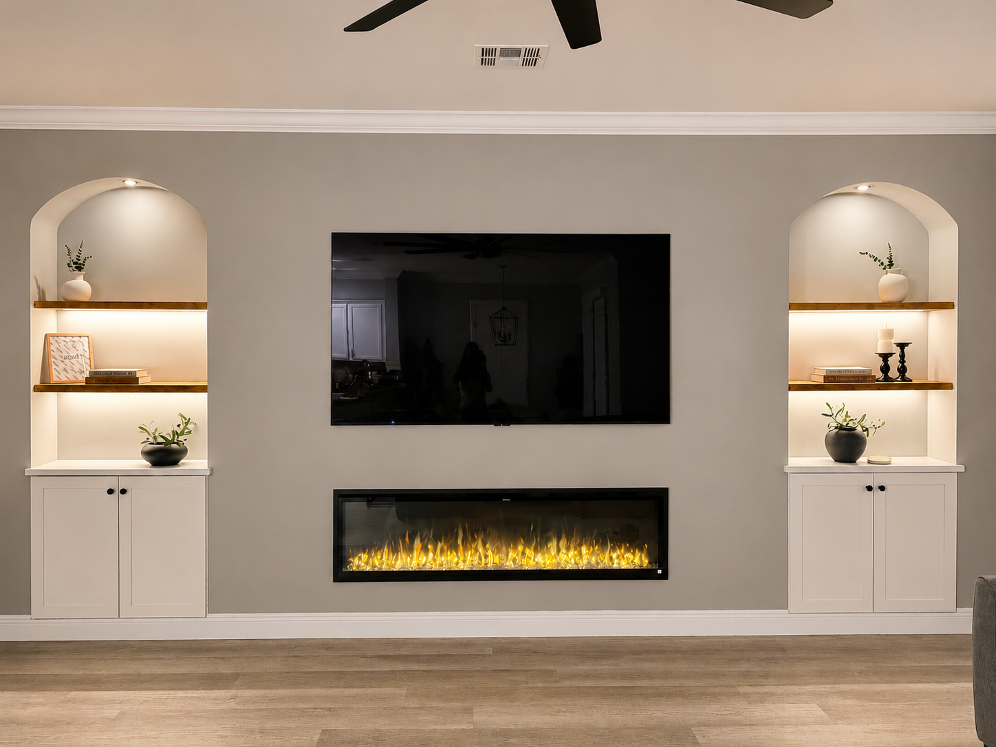 Custom fireplace feature wall with built-in shelving, electric fireplace, and entertainment center designed and installed by Reliable Home Repairs.
