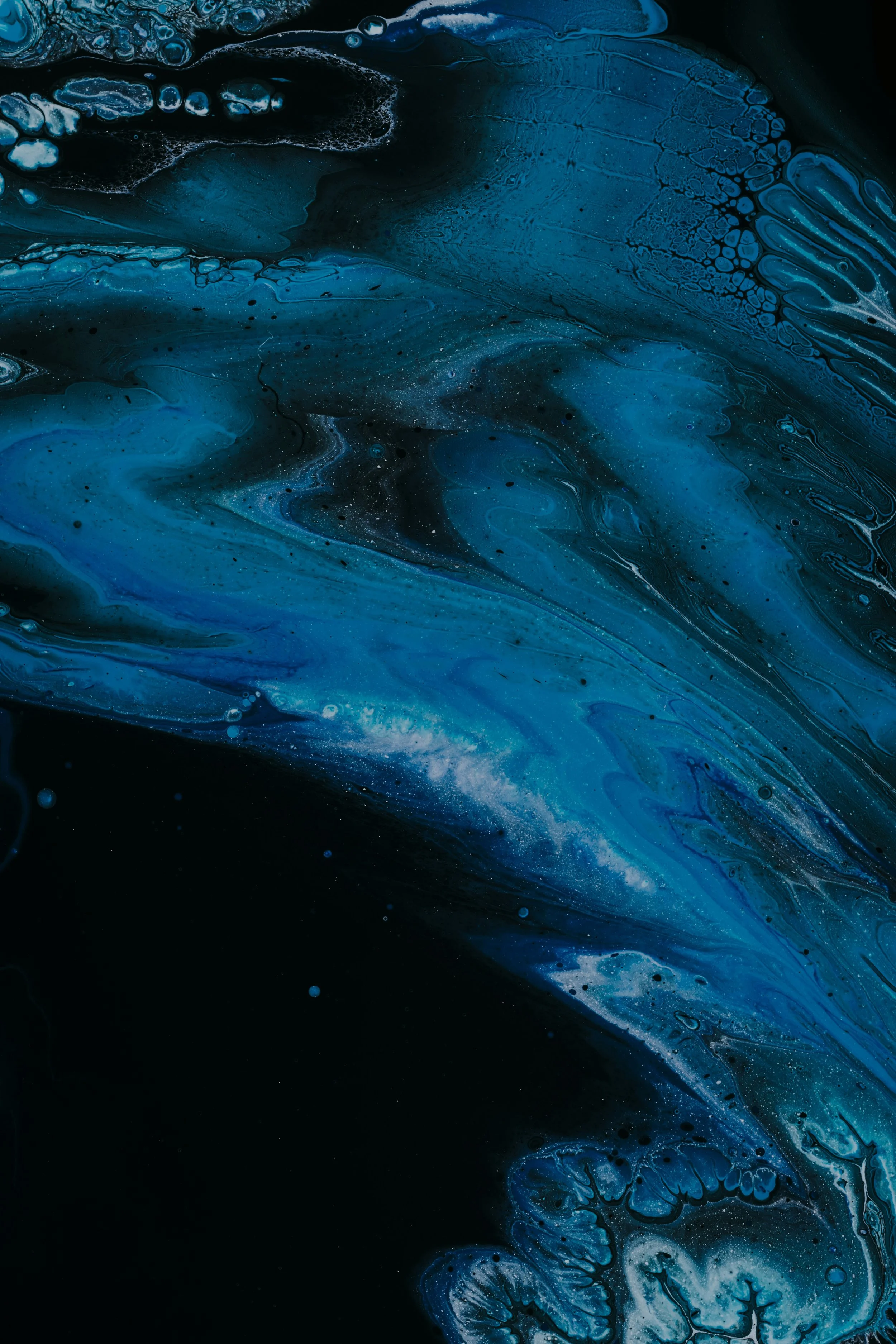 Abstract artwork with swirling patterns of dark blue, light blue, and black colors.