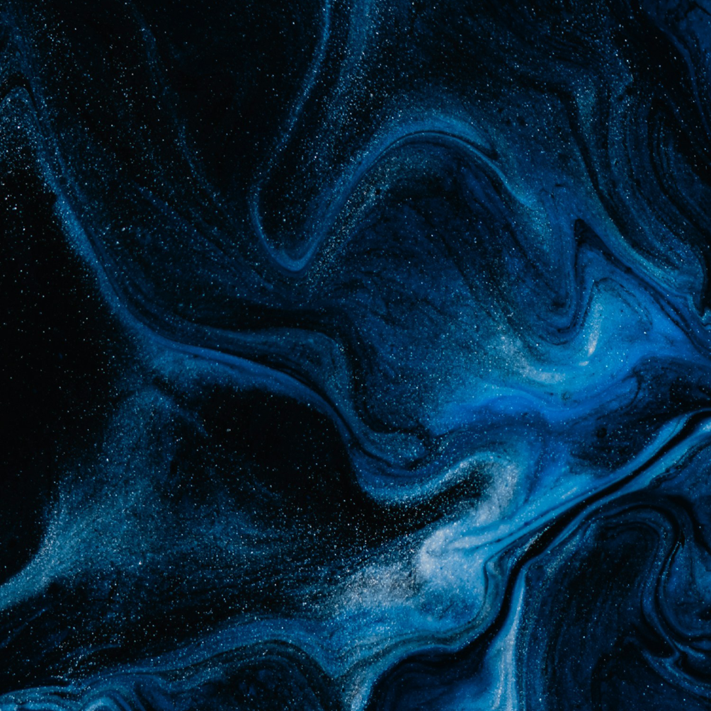 Swirling blue and black cosmic or nebula-like abstract background with specks resembling stars