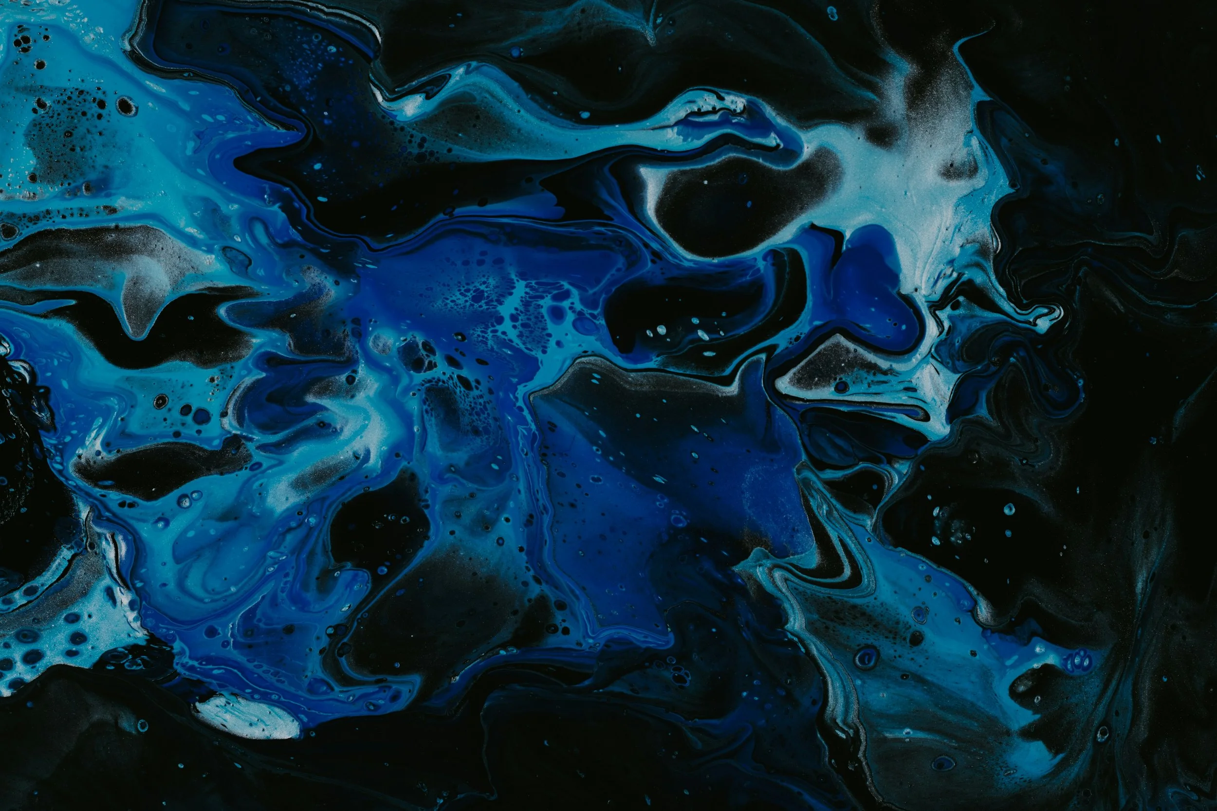 Abstract fluid art painting with swirling black, blue, and white colors
