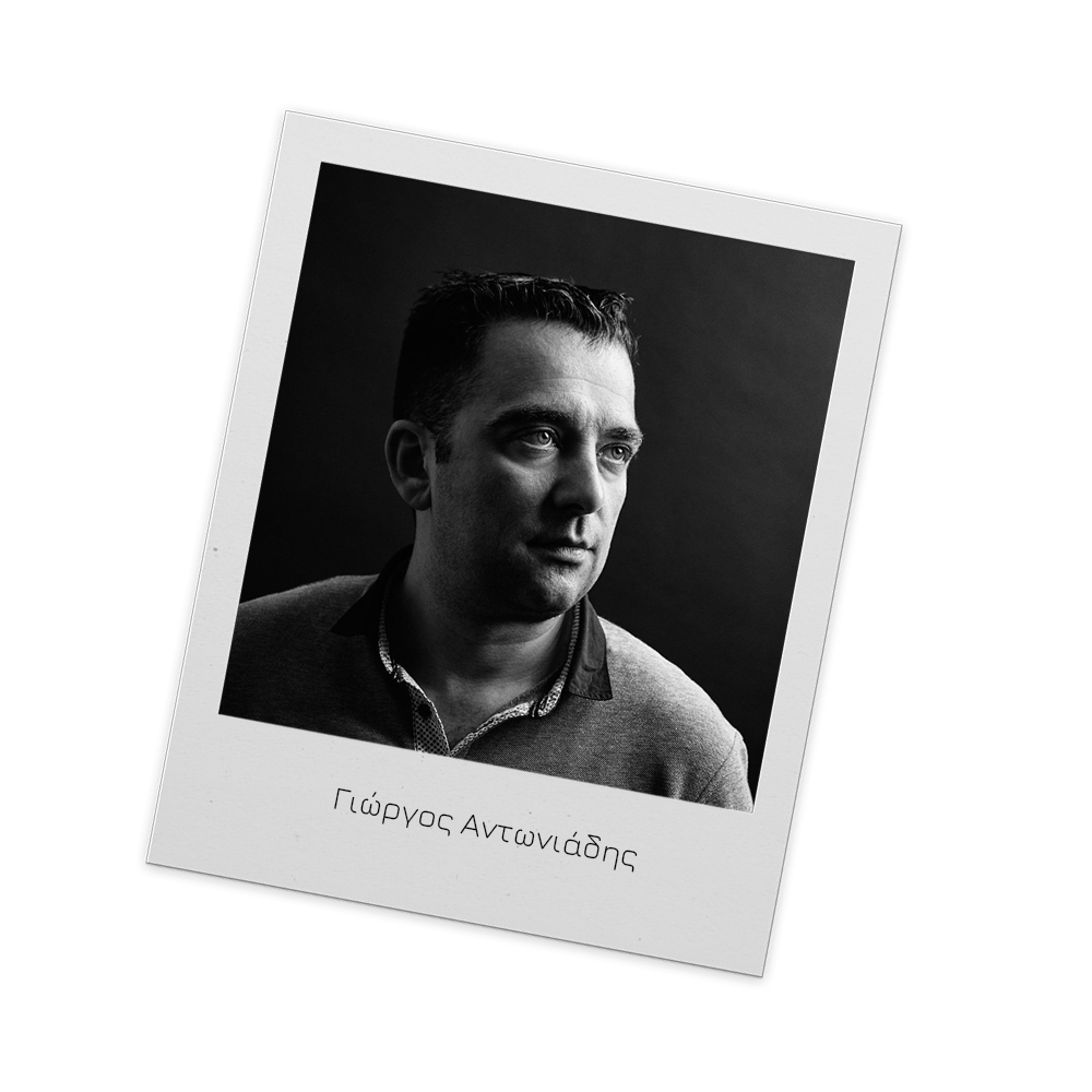 Black and white portrait of a man looking to the side, in a Polaroid frame with Greek text that reads 'Γιώργος Αντωνιάδης'.