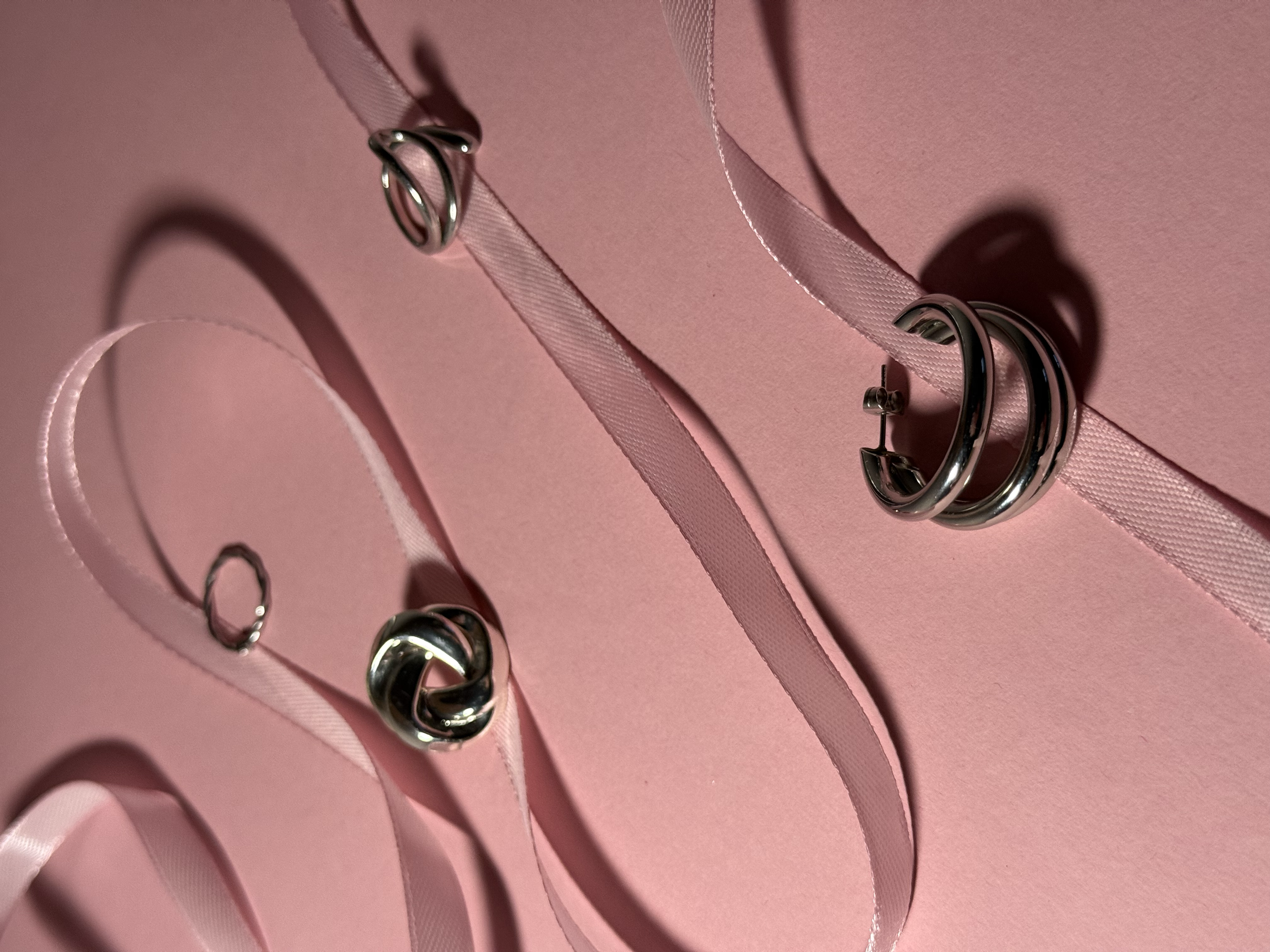 Maak met meerdere ringen en beige linten op een roze achtergrond.