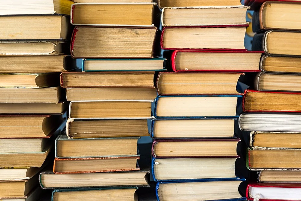Stacks of books arranged vertically with various colored covers.