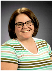 A woman with short brown hair, glasses, and a striped green, white, and brown shirt smiling against a gray background.