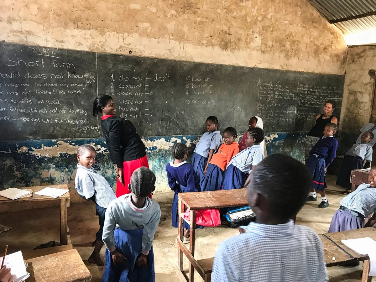 Schulkinder stehen vor einer grossen Wantafel im Schulzimmer der Hilfsorganisation Nafrika