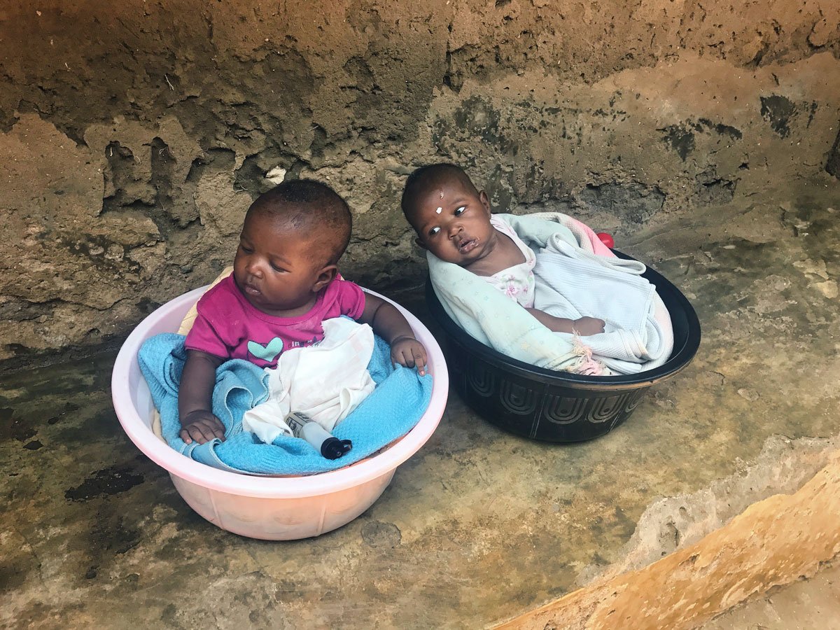 Zwei Babys sitzen in kleinen Plastikeimern. Sie wurden von der Organisation Nafrika medizinisch versorgt