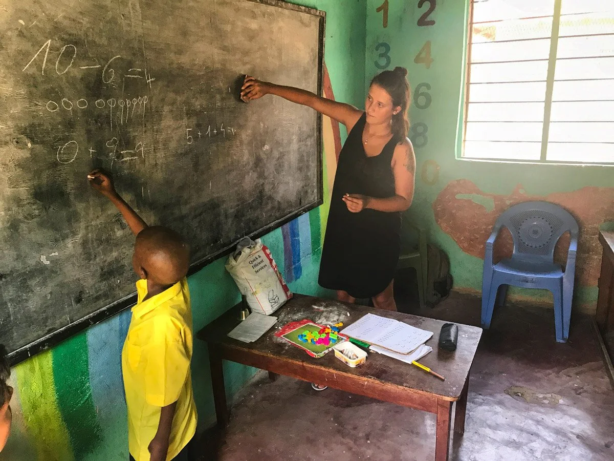 Nathalie Narbel steht mit einem Schüler vor der Wandtafel und unterrichtet die Klasse