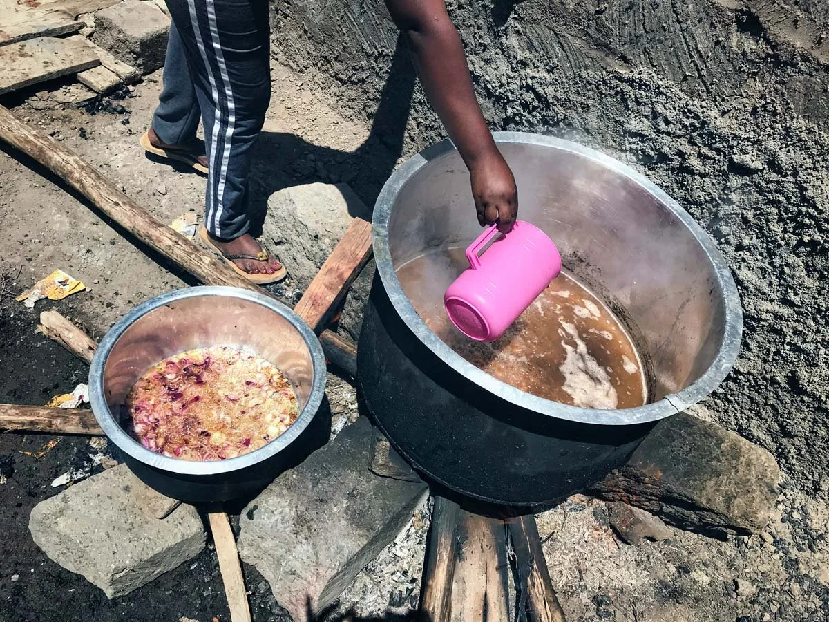 Die junge Schweizerin Nathalie Narbel bereitet in zwei grossen schwarzen Kochtöpfen aus Blech Essen für die obdachlosen Strassenkinder von Nairobi-Afrika zu