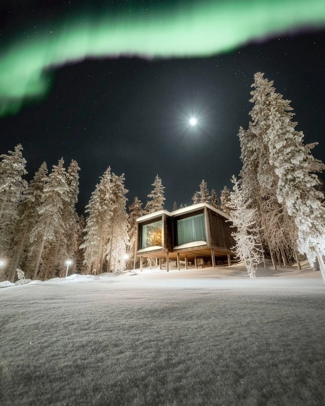 Northern lights from bed. No parka required.

Welcome to Arctic TreeHouse Hotel in Rovaniemi, Finland. The suites sit up on stilts among the pines, each with a huge glass wall facing due north, so on a clear winter night the aurora shows up while you