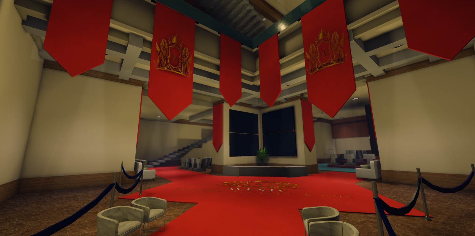 An elegant hotel lobby with red carpet and hanging red banners with gold emblem, white chairs, and a gray stage area at the front.