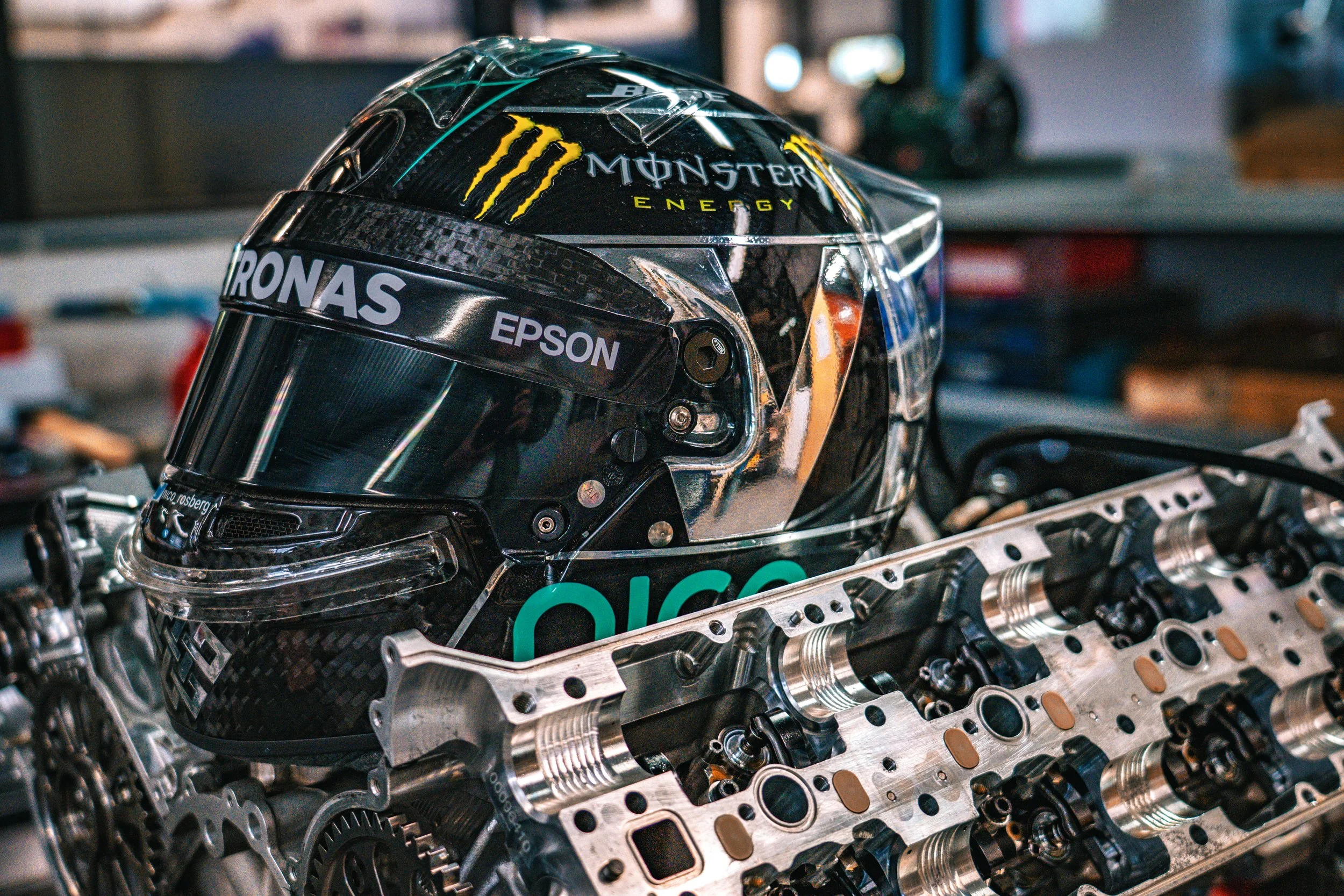 Casque de pilote de course placé sur un moteur d'automobile dans un atelier.