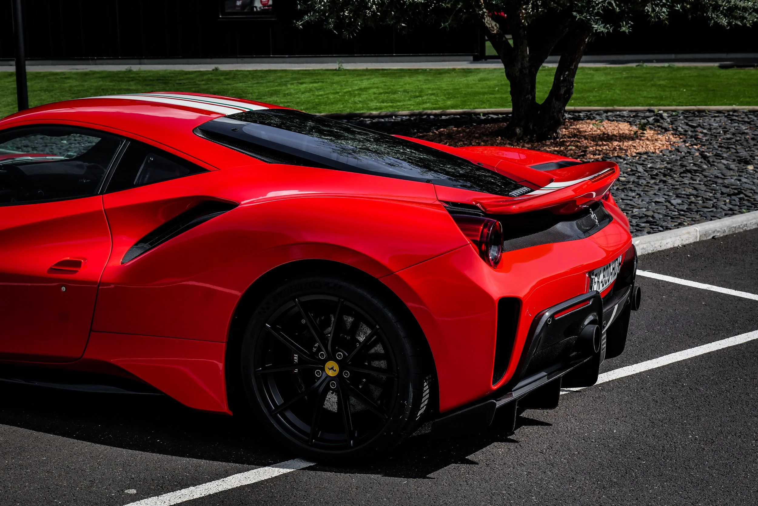Voiture Ferrari rouge de sport garée dans une place de parking.