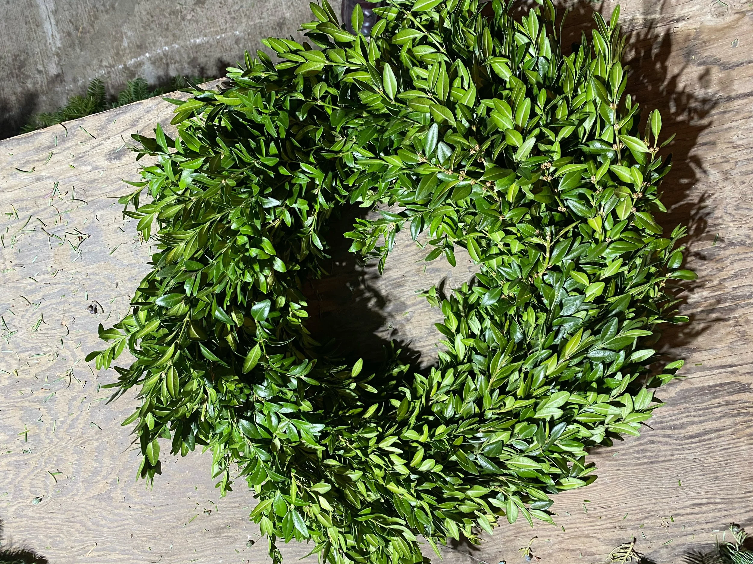 Green leafy wreath on a wooden surface.